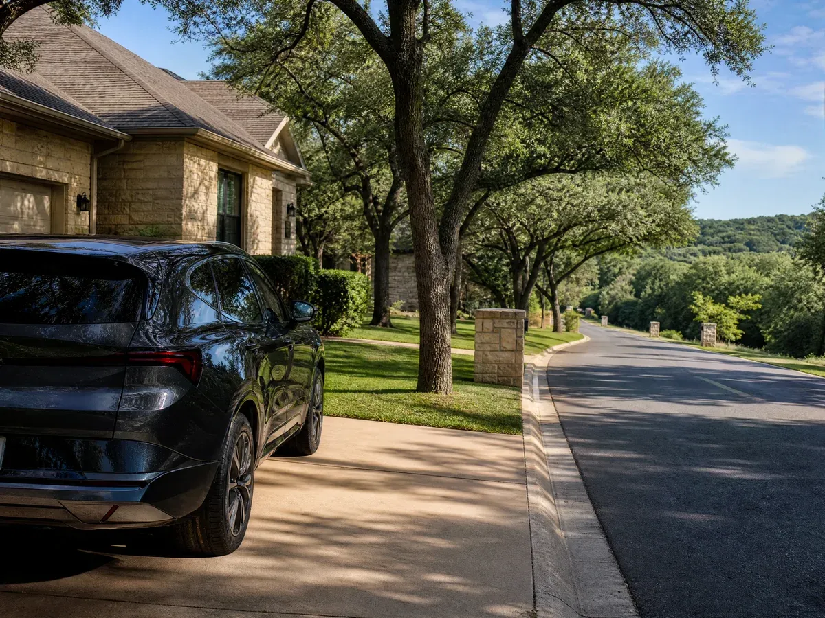 A limestone-toned residential street in Georgetown with a car parked in a driveway — Scarabbodyworks Detailing in Georgetown, TX.