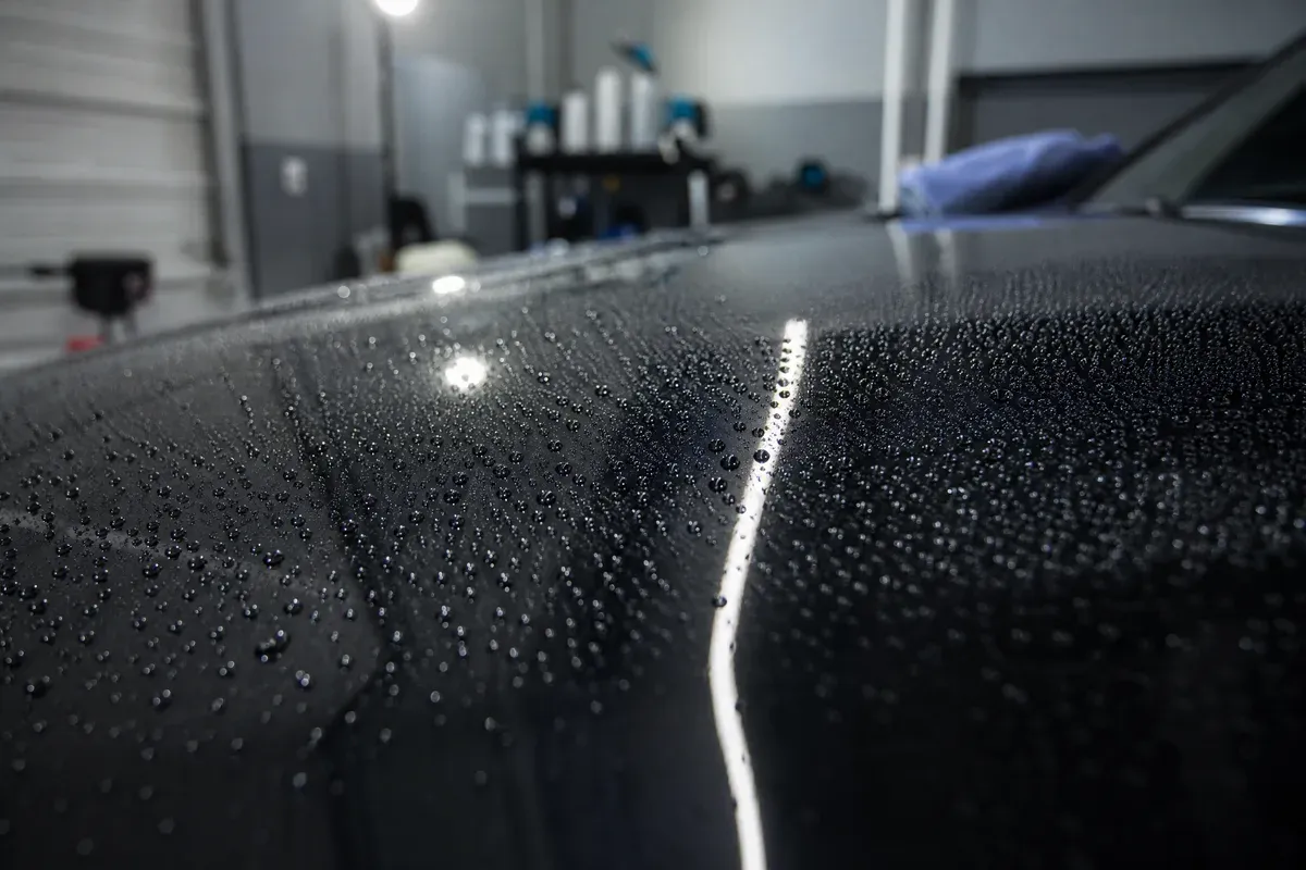 Water beading on a ceramic coated hood inside the Buda shop, showing how a coating sheds water in Central Texas