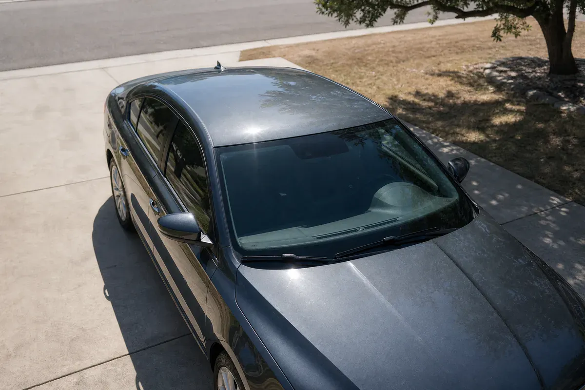 Hard Central Texas midday sun on the roof and hood of a vehicle parked in an open driveway